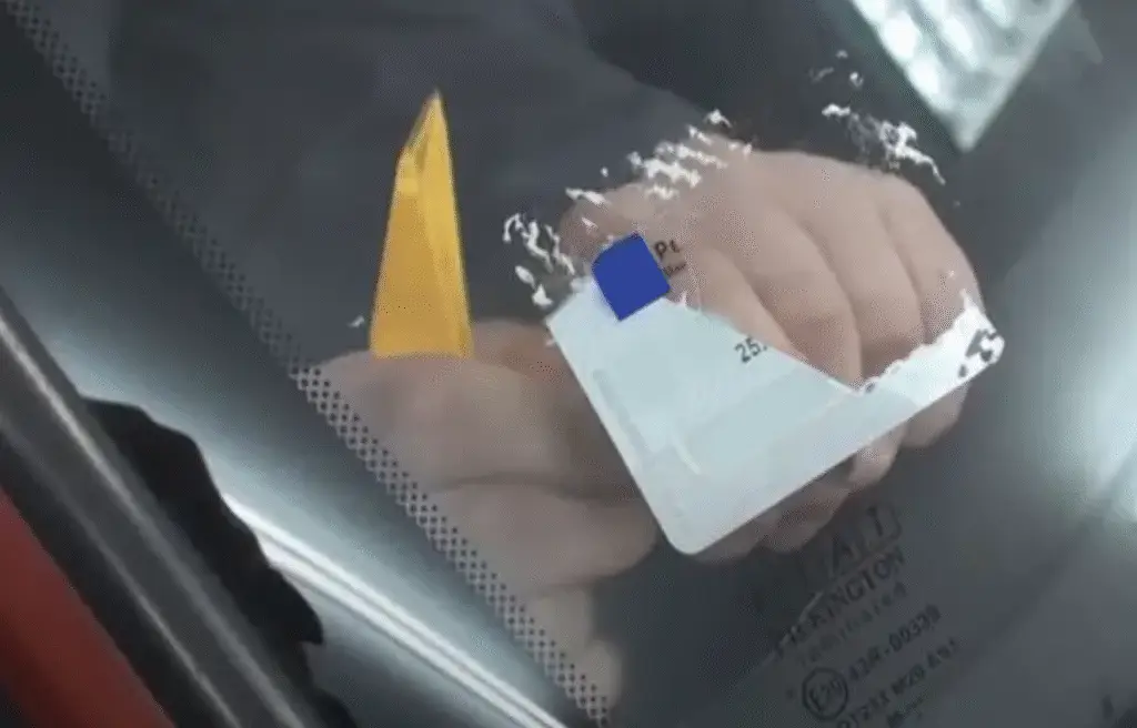 ruka postavlja dokument uz vetrobran vozila tokom izdavanja zelenog kartona